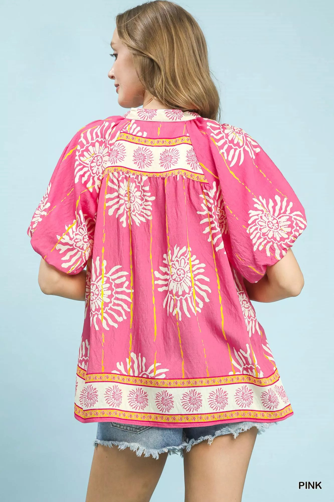 Pink Umgee floral border boho blouse with smocked V-neck and long sleeves, featuring a relaxed, feminine style.