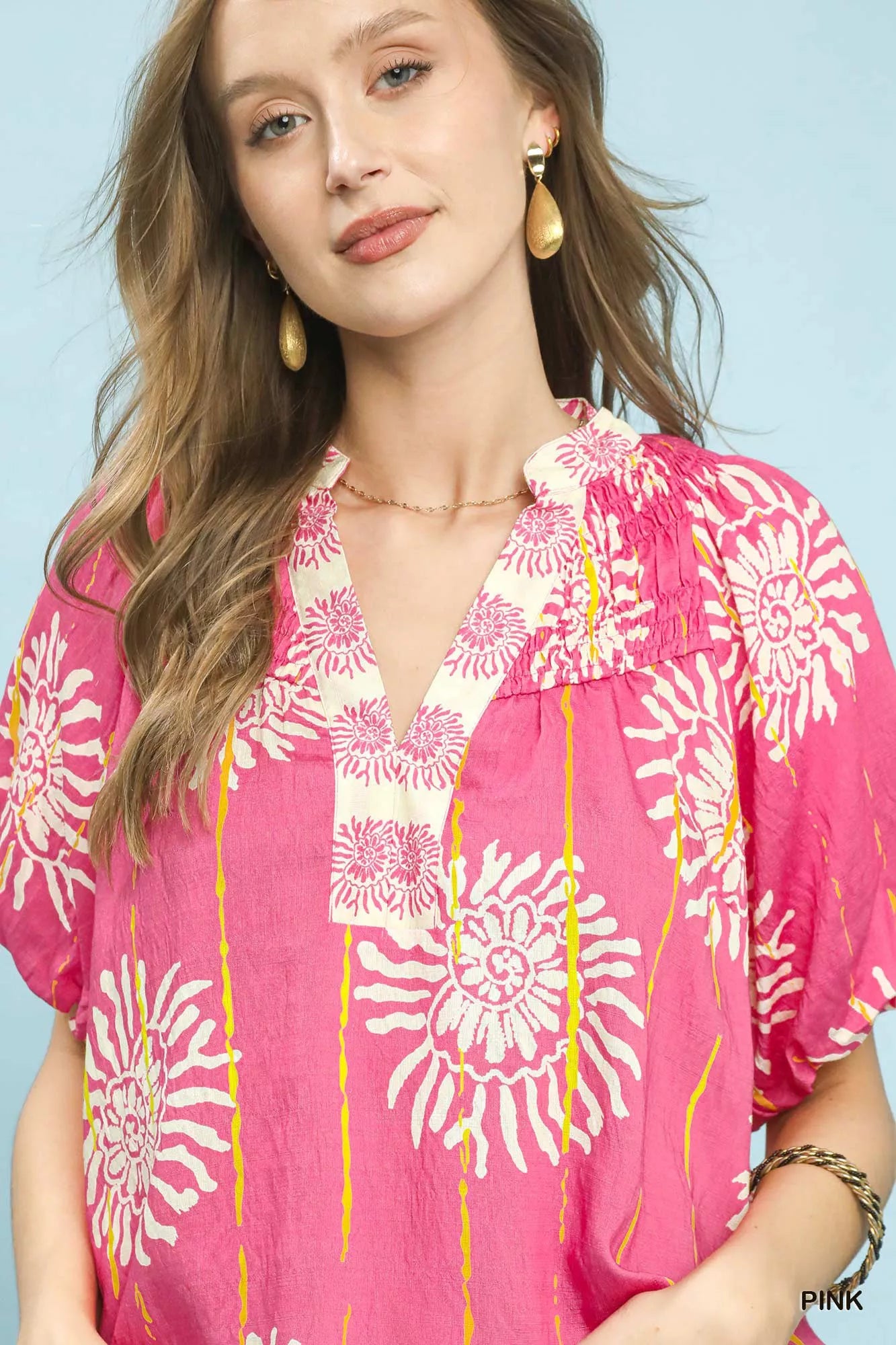 Pink Umgee floral border boho blouse with smocked V-neck, featuring a relaxed fit and floral pattern.