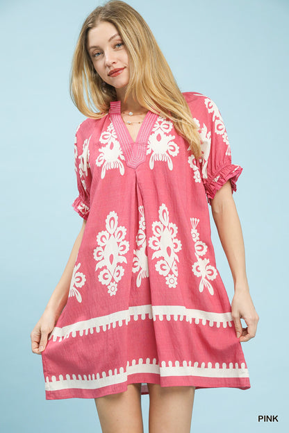Pink Umgee two-tone border print mini dress with short sleeves, displayed on a hanger against a neutral background.