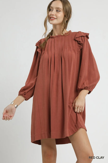 Red clay Umgee linen babydoll dress with ruffle shoulder and pleated design, featuring a relaxed, feminine fit.