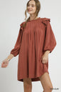 Red clay Umgee linen babydoll dress with ruffle shoulder and pleated design, featuring a relaxed, feminine fit.