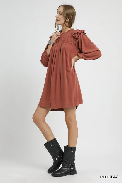 Red clay Umgee linen babydoll dress with ruffle shoulder detail and pleated skirt, perfect for casual summer wear.