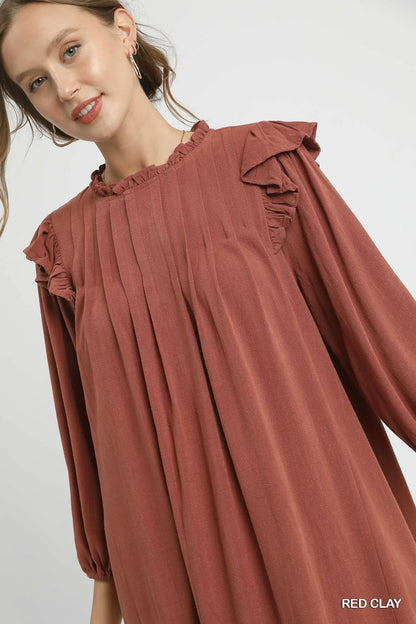 Red clay Umgee linen babydoll dress with ruffle shoulders and pleated skirt, featuring a relaxed, feminine fit.
