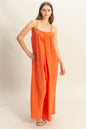 Red-orange HYFVE double gauze cami jumpsuit with a flowy silhouette, featuring thin straps and a relaxed fit.