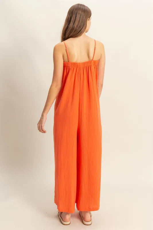 Red-orange HYFVE double gauze cami jumpsuit with a super flowy, relaxed fit, featuring thin straps and a stylish, comfortable design.