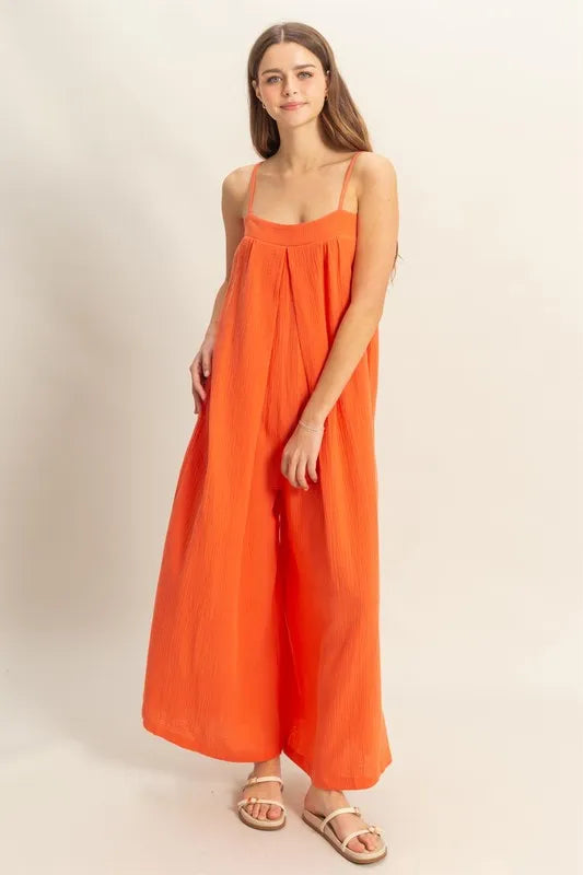 Red-orange HYFVE double gauze cami jumpsuit with a super flowy fit, featuring a sleeveless design and relaxed silhouette.