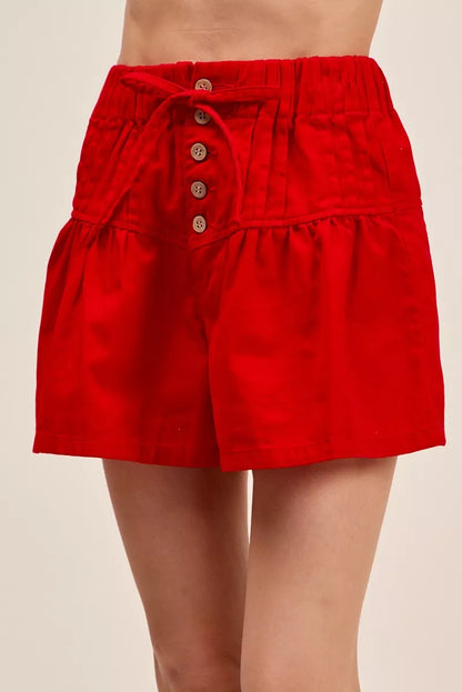 Trendsi red solid twill denim pintucked buttoned shorts with waist tie, casual summer shorts for women, front view.