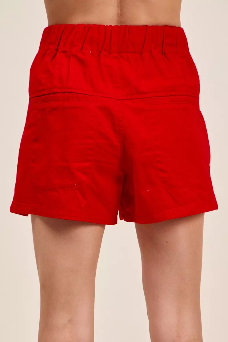Red Trendsi SO ME solid twill denim pintucked buttoned shorts with waist tie, shown on a model.