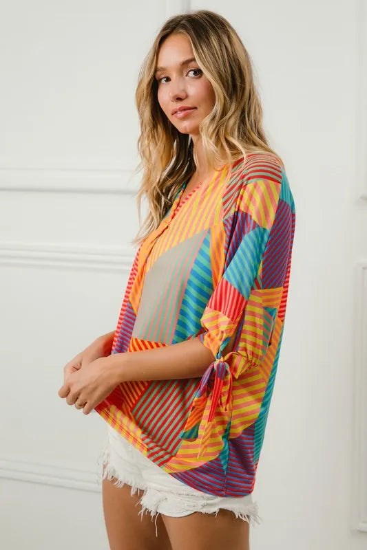 Red, yellow, and green striped jersey blouse with tie sleeves from Trendsi, featuring multi-color block print and relaxed fit.