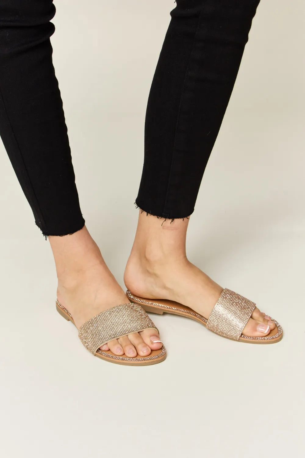 Rose gold WILD DIVA rhinestone open toe flat sandals by Trendsi, featuring sparkling rhinestones and a comfortable flat sole.