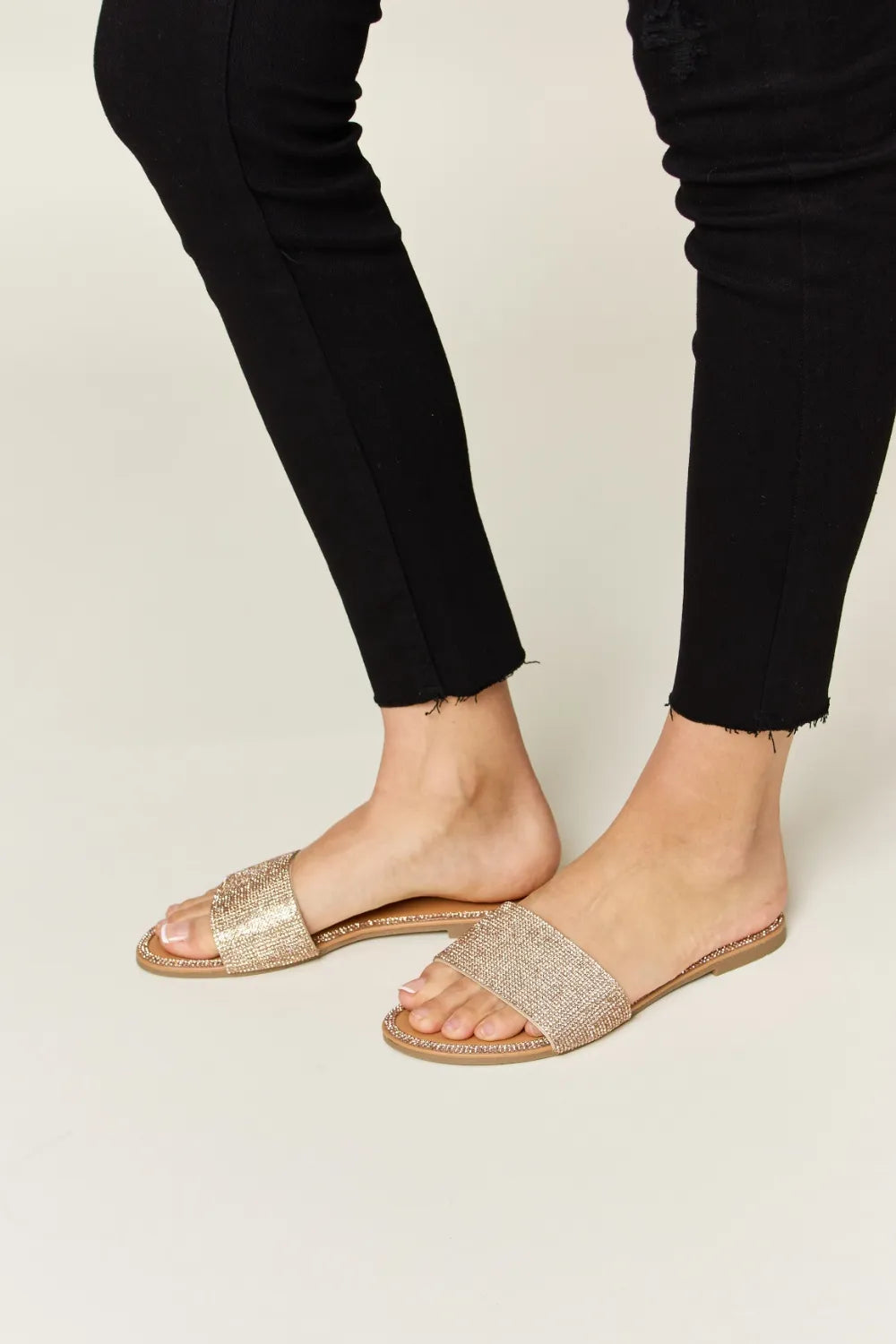 Rose gold WILD DIVA rhinestone open toe flat sandals from Trendsi, featuring sparkling rhinestones and a comfortable flat sole.