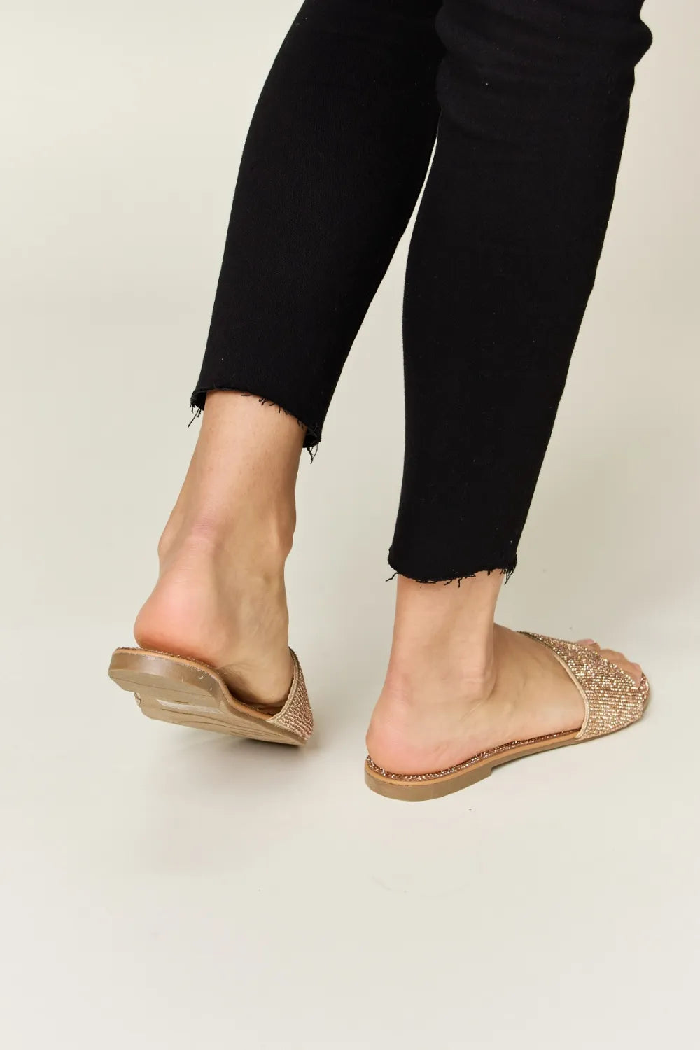 Rose gold Wild Diva rhinestone open toe flat sandals with stylish straps and sparkling details, perfect for casual or dressy occasions.