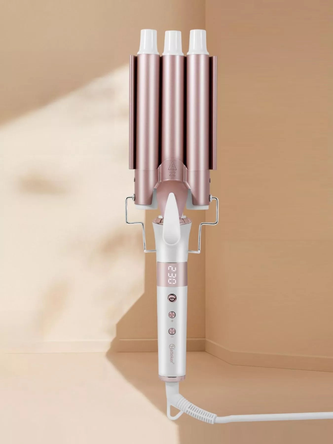 Rose gold 3-barrel hair curling iron from Trendsi with European plug for creating defined, beachy waves or tight curls.