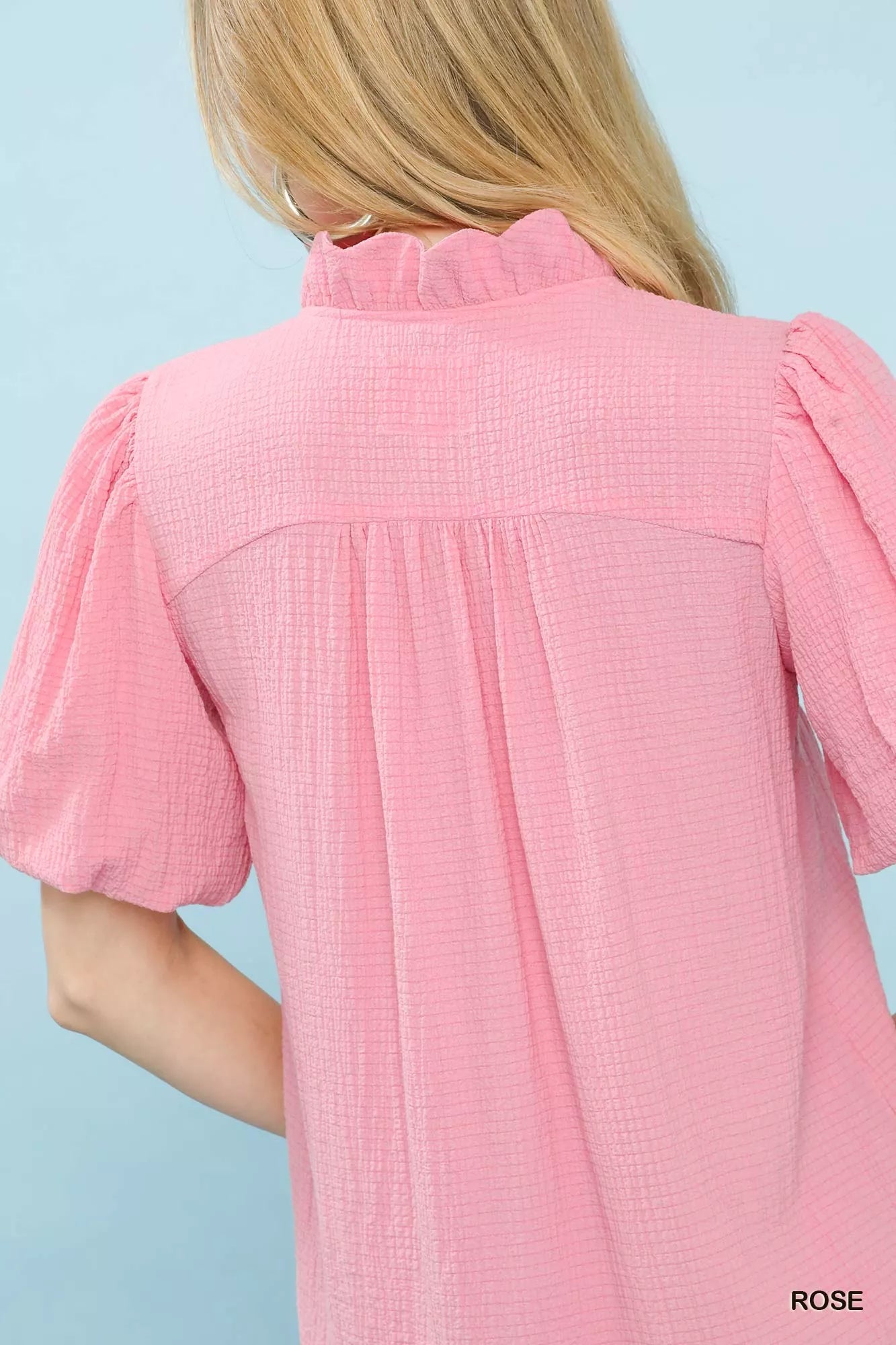 Pink Umgee Seersucker Puff Sleeve Blouse featuring a relaxed fit and ruffled cuffs, displayed on a hanger.