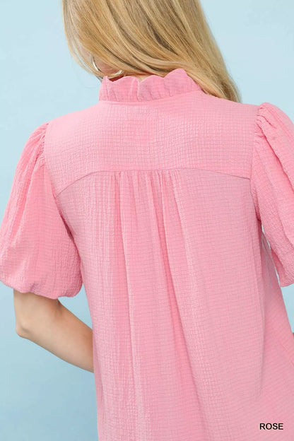 Pink Umgee Seersucker Puff Sleeve Blouse featuring a relaxed fit and ruffled cuffs, displayed on a hanger.