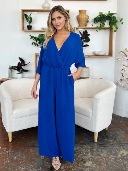 Royal blue Trendsi Double Take full-size surplice wide-leg jumpsuit with pockets, featuring a relaxed fit and stylish design.