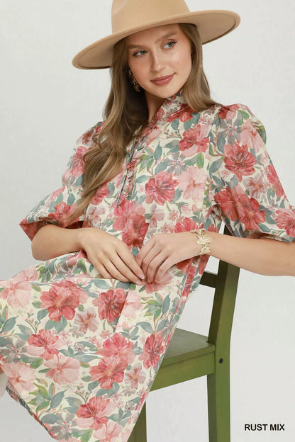 Rust-colored Umgee floral print mini dress with smocked cuffs, featuring a mix of floral patterns and a casual, stylish fit.