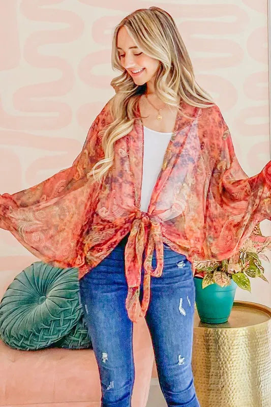 Rust-colored oversized print top with front tie knot from Trendsi, featuring a casual, relaxed fit and bold graphic design.