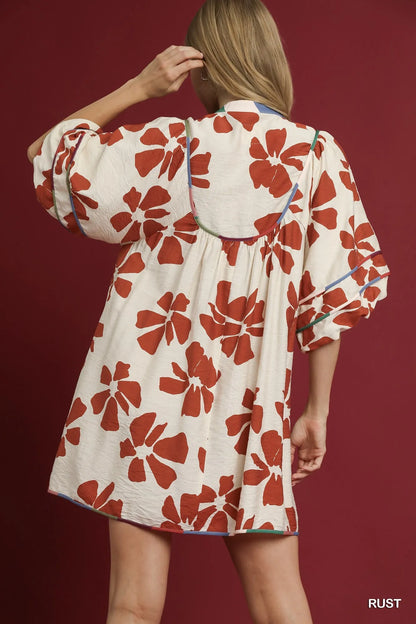 Rust-colored Umgee two-tone floral tie-neck babydoll dress with long sleeves and a relaxed fit, perfect for casual wear.