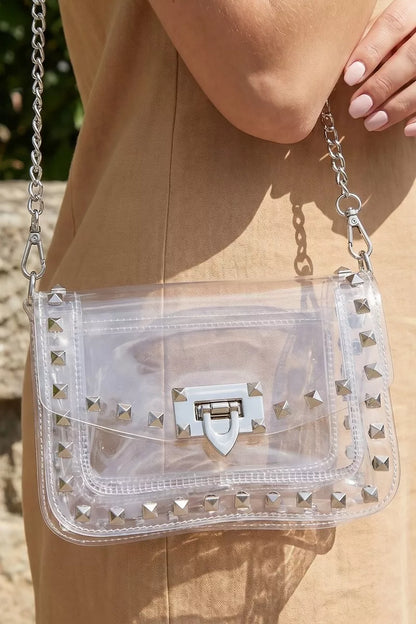 Clear stadium bag with studded design and chain strap from Trendsi, featuring a spacious interior and stylish crossbody style.