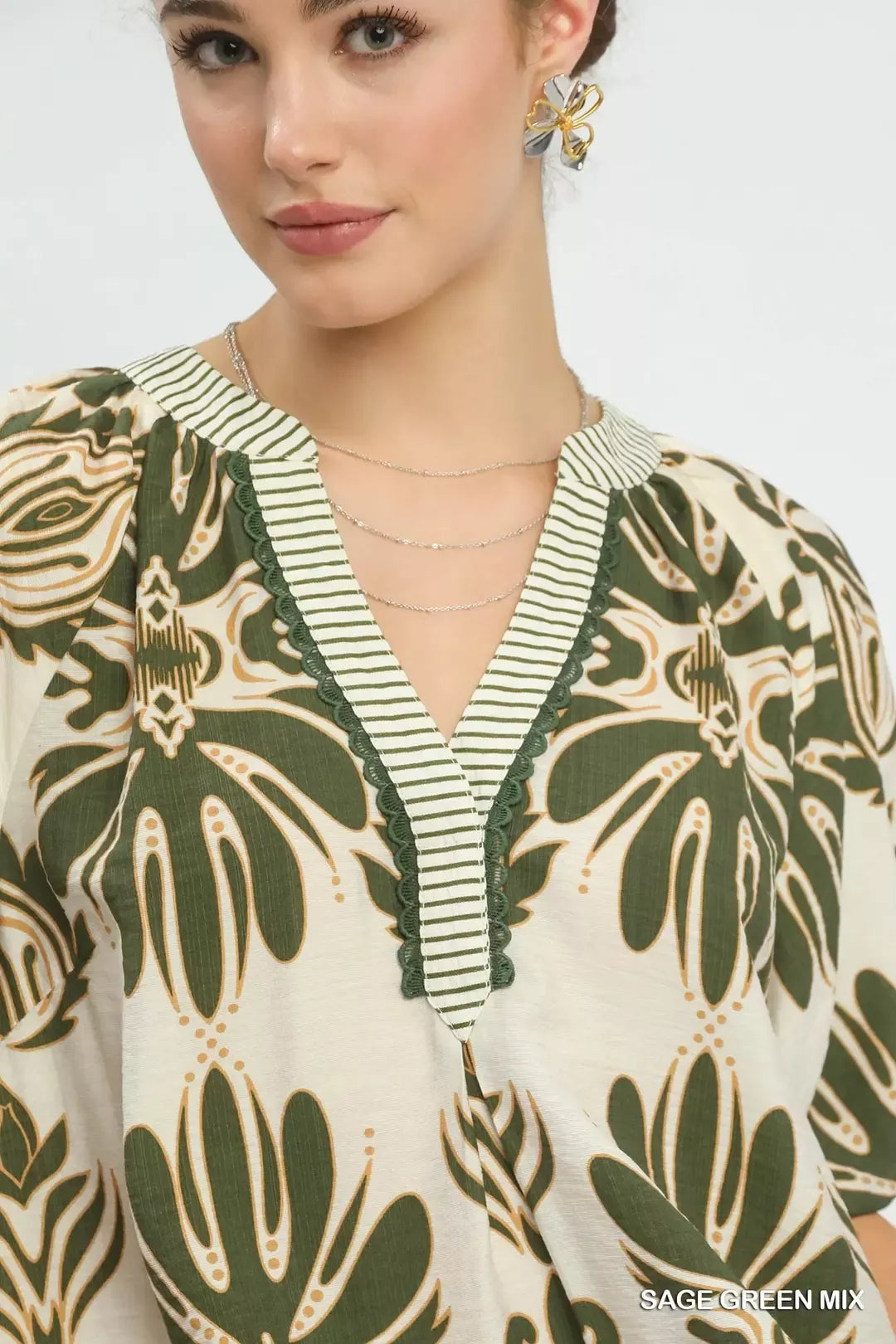 Sage green Umgee printed puff sleeve top with contrast trim, featuring a mix of patterns and stylish puff sleeves.