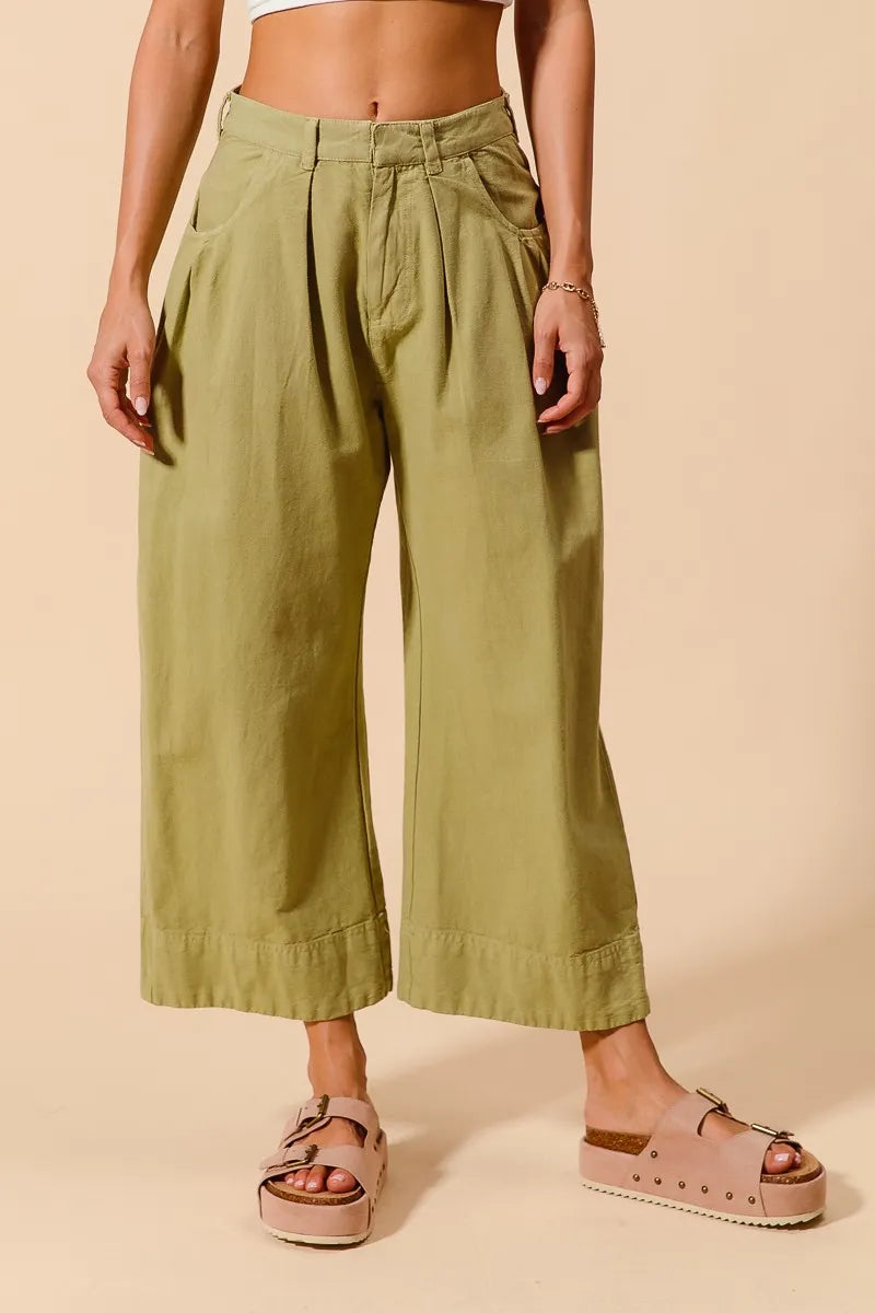 Sage green SO ME mid-rise wide-leg chino pants with front and back pockets, stylish and comfortable for casual wear.