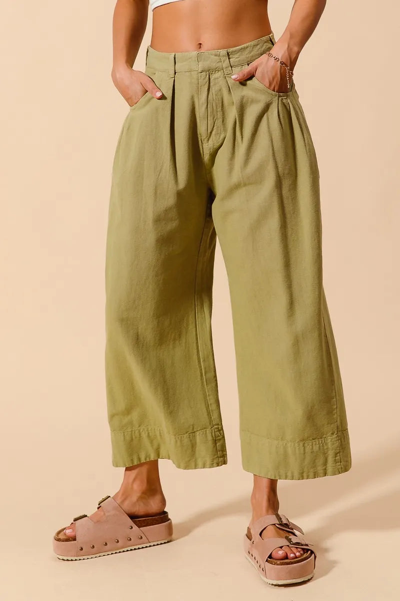 Sage green SO ME mid-rise wide leg chino pants with front and back pockets, made by Trendsi, displayed on a model.