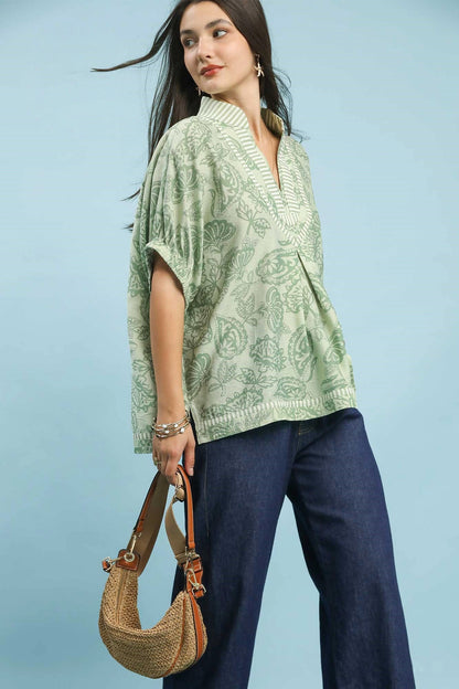 Umgee botanical print mixed trim tunic top by Trendsi, featuring floral design and relaxed fit, displayed on a neutral background.