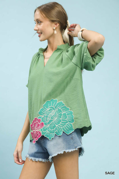 Sage green Umgee floral embroidered hem blouse with long sleeves and relaxed fit, showcasing intricate embroidery details.