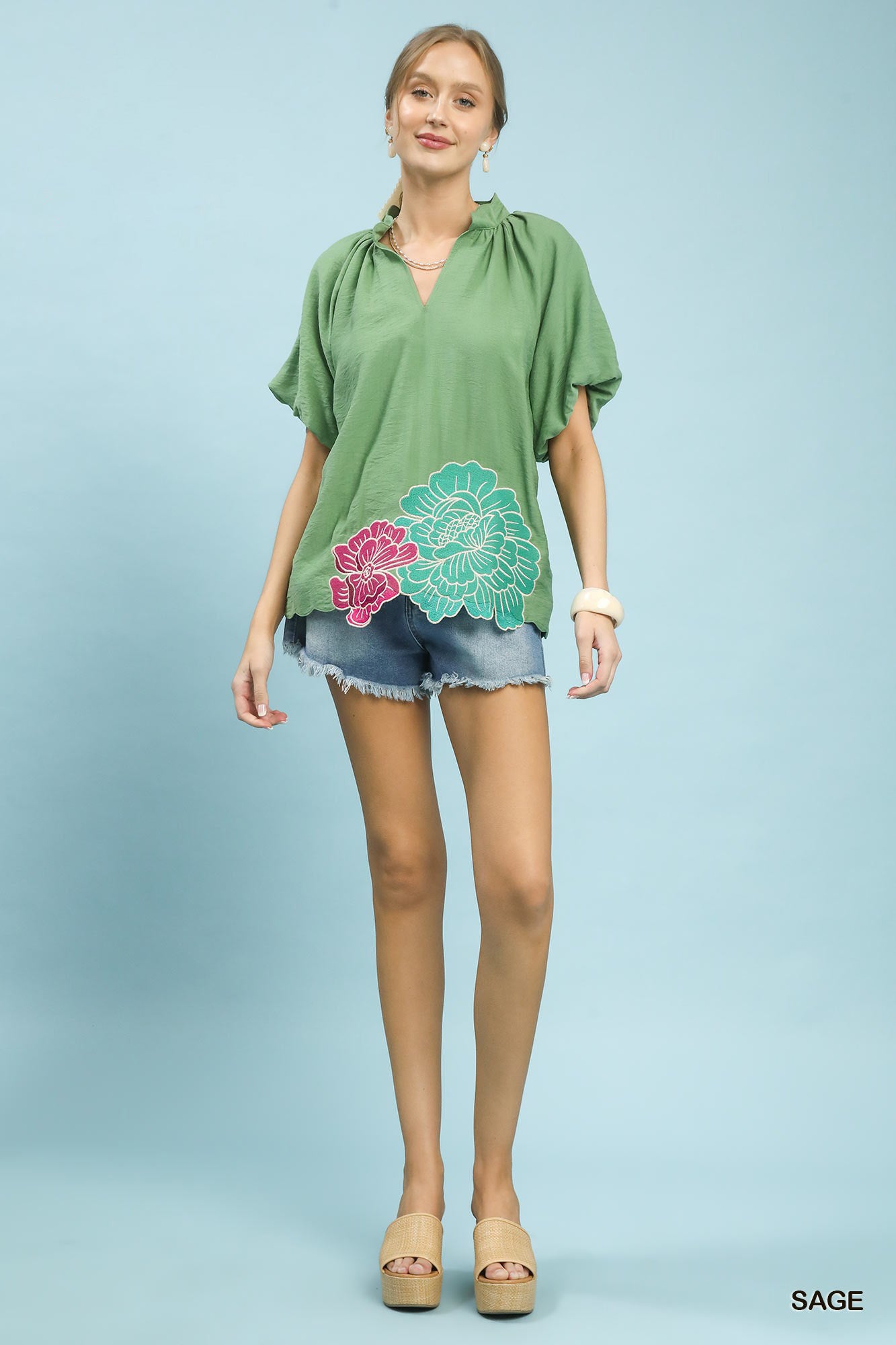 Sage green Umgee floral embroidered hem blouse with long sleeves and flowy fabric, styled with intricate floral embroidery.