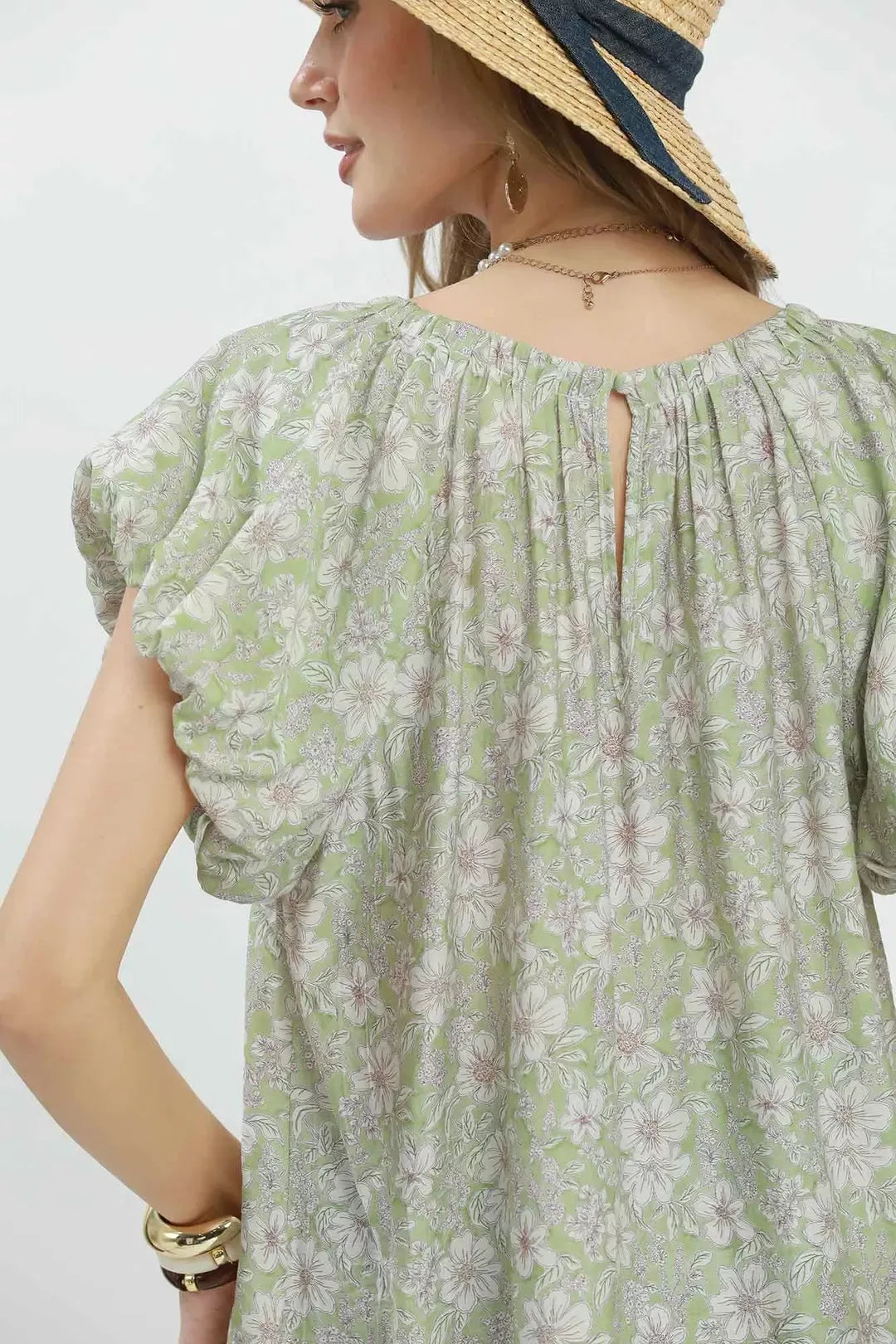 Sage green Umgee floral puff sleeve blouse with ruffled cuffs and a relaxed fit, styled with a floral pattern and lightweight fabric.