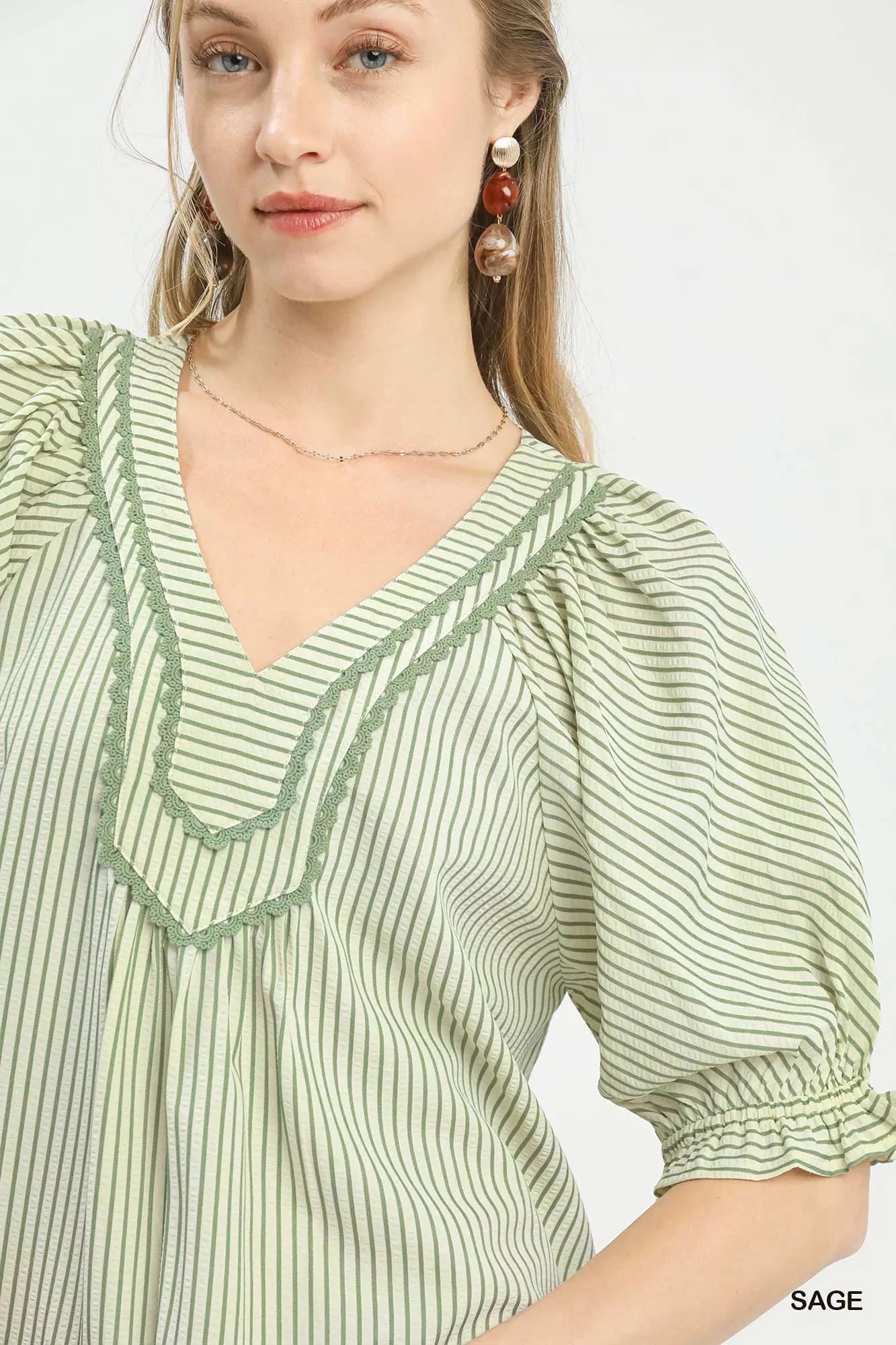 Sage green Umgee Stripe V-Neck Blouse with long sleeves and relaxed fit, styled with subtle vertical stripe pattern.