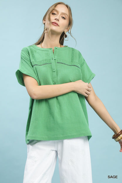 Sage green Umgee boho blouse with textured gauze fabric, split neckline, long sleeves, and relaxed fit, styled for casual wear.