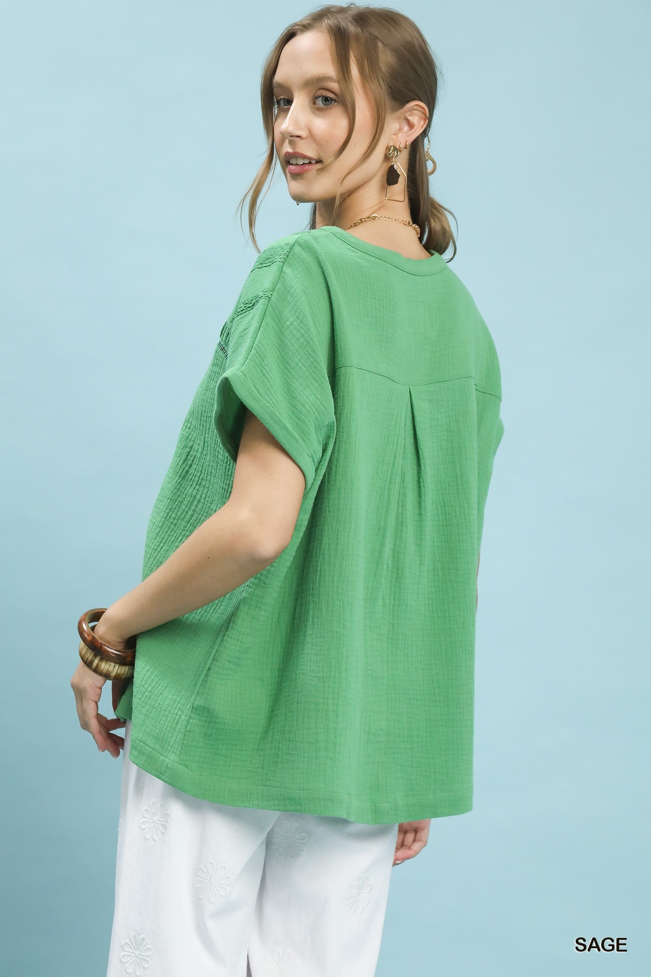 Sage green Umgee boho blouse with textured gauze fabric and split neckline, featuring a relaxed fit and casual style.