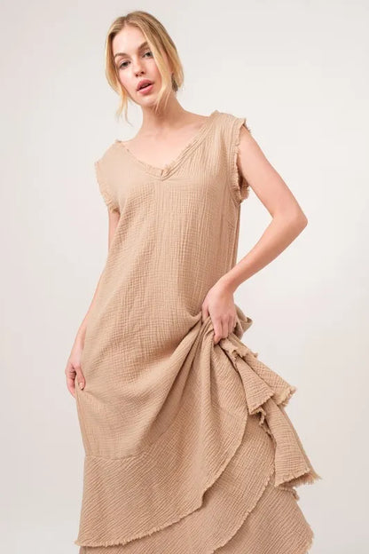 Sand-colored And The Why washed fringe detail tiered dress with layered fabric and fringe accents, displayed on a hanger.