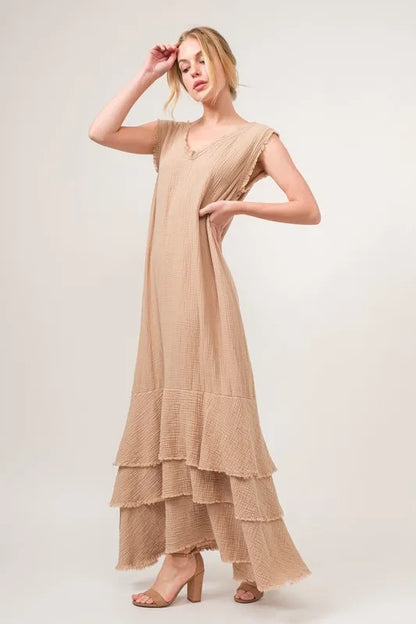 Sand-colored tiered dress with washed finish and fringe details from Trendsi's And The Why collection, styled with flowing fabric.