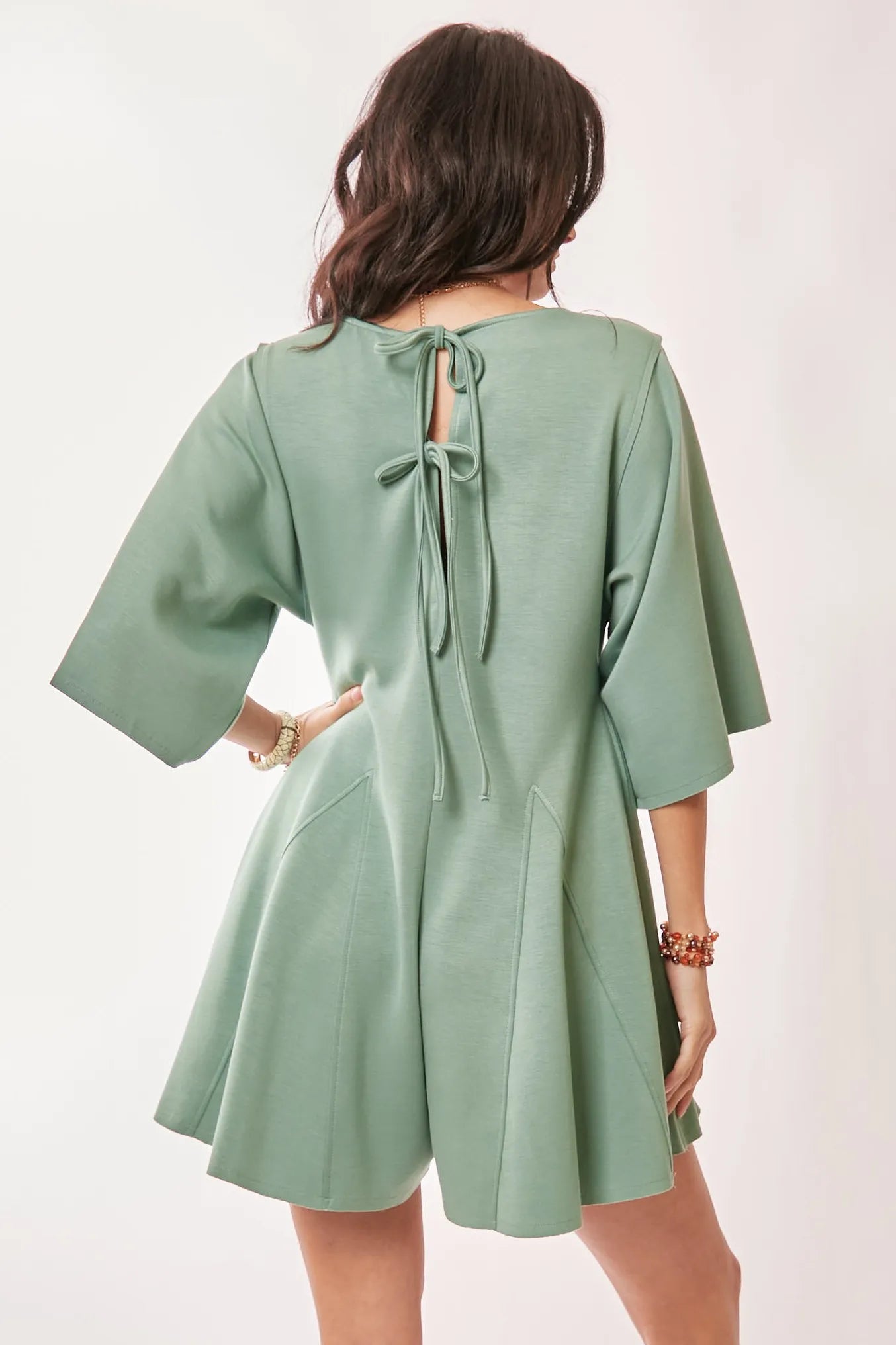 Seafoam green Davi & Dani romper with draped sleeves and ties at the back, featuring a stylish skort design.