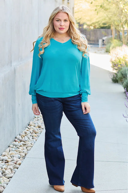 Sky-blue Basic Bae full-size V-neck lantern sleeve top by Trendsi, featuring a relaxed fit and stylish long lantern sleeves.