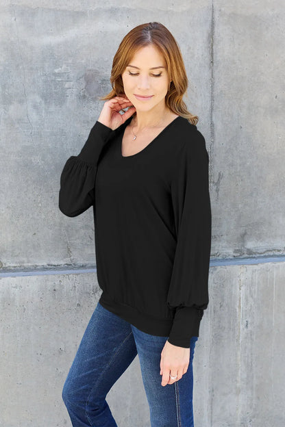 Sky blue Trendsi Basic Bae full-size V-neck lantern sleeve top displayed on a mannequin with a relaxed fit and stylish design.