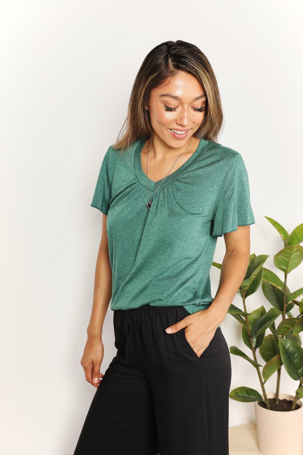 Sky blue Trendsi Double Take Ruched V-Neck Short Sleeve T-Shirt displayed on a model, showcasing a fitted, stylish casual top.