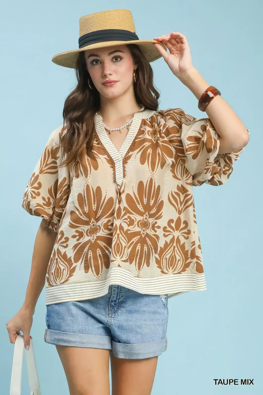 Taupe Umgee mix printed puff sleeve top with contrast trim, showcasing stylish design and fabric details.