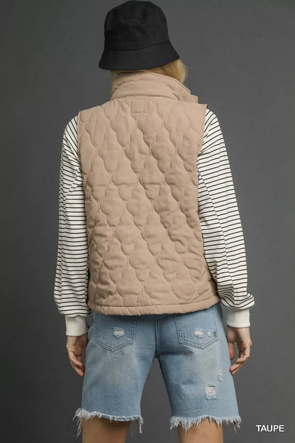 Taupe Umgee quilted zip-up vest with front pockets, styled for a casual look. Trendy and lightweight for layering.