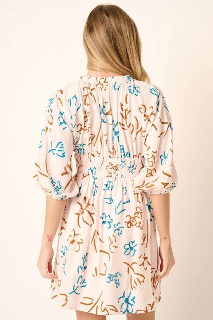 Teal flower print mini dress by Mittoshop with a mocked waist, styled with short sleeves and a fitted silhouette.