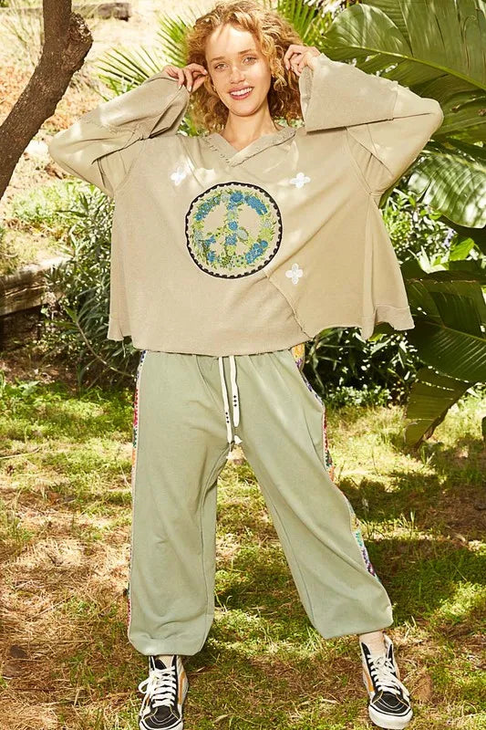 Wheat grass POL Peace embroidered V-neck top with exposed seams and ruffle details, featuring a stylish back design.
