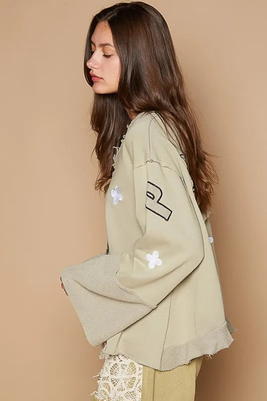 Wheat-colored Trendsi POL Peace embroidered V-neck top with exposed seam back and ruffle detail, showcasing stylish casual fashion.