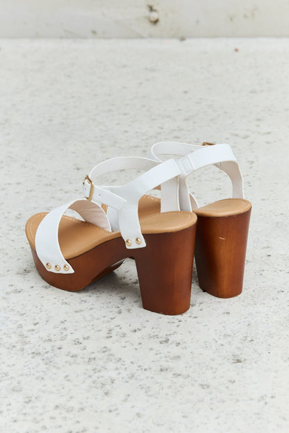 White DDK Time After Time wooden platform strap heels by Trendsi, featuring ankle straps and chunky wooden heels.