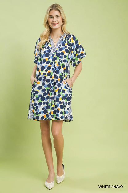 White and navy polka dot print Umgee tunic dress by Trendsi, featuring a relaxed fit and feminine style.