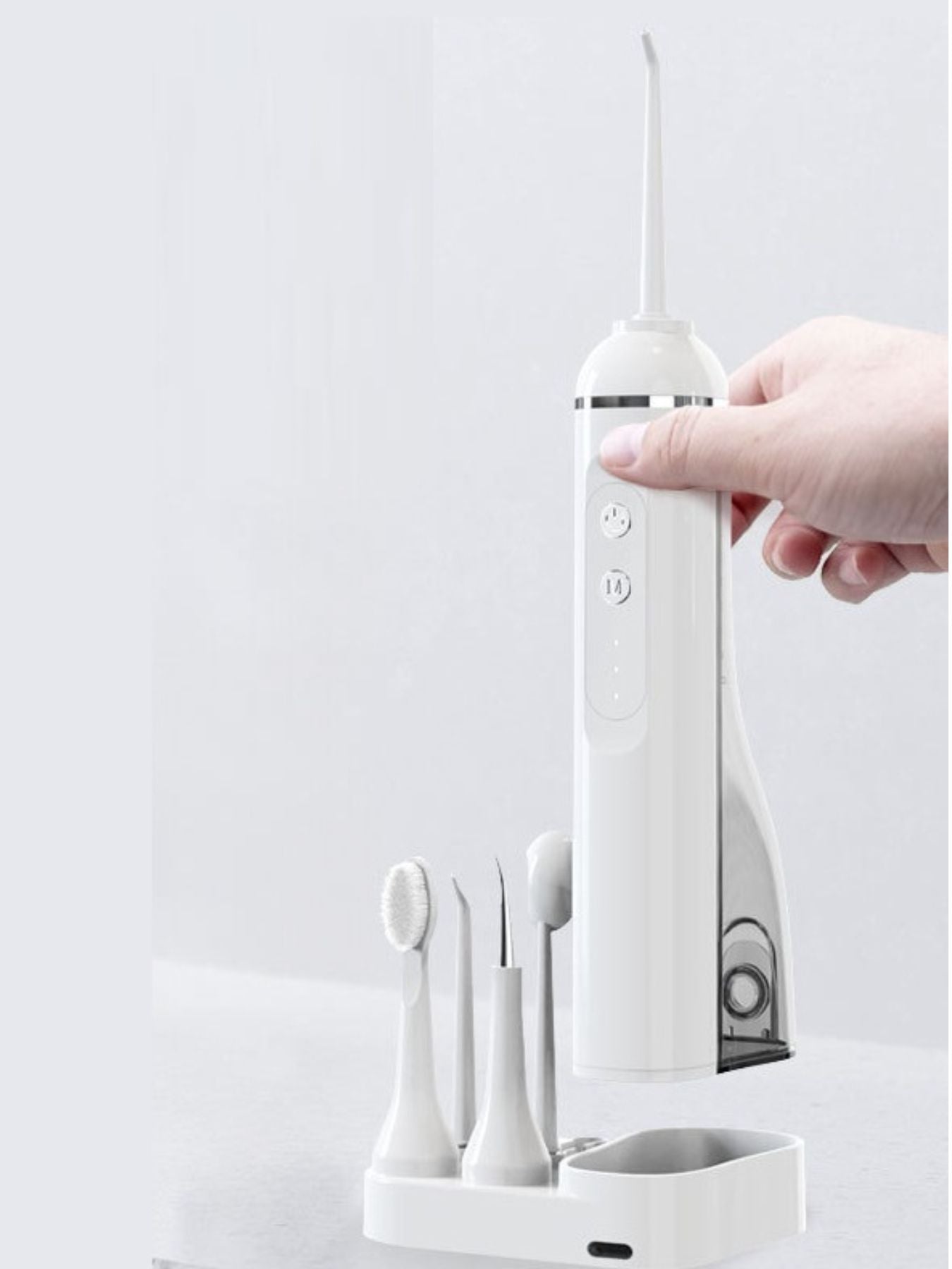 White portable water flosser with multiple nozzles, compact design, and ergonomic handle for effective oral hygiene.