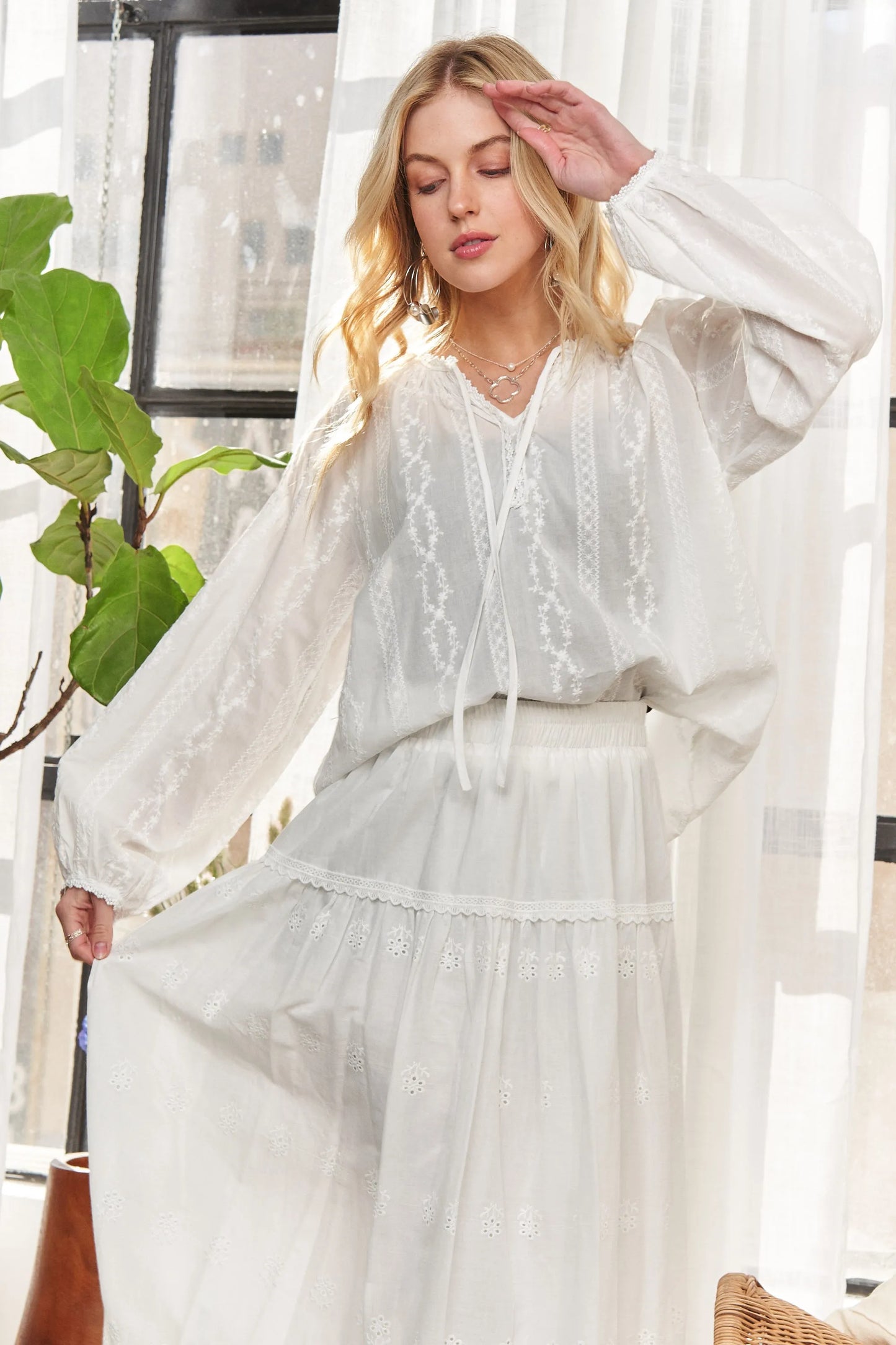 White ADORA cotton peasant top with a relaxed fit and gathered neckline, featuring long sleeves and lightweight fabric.