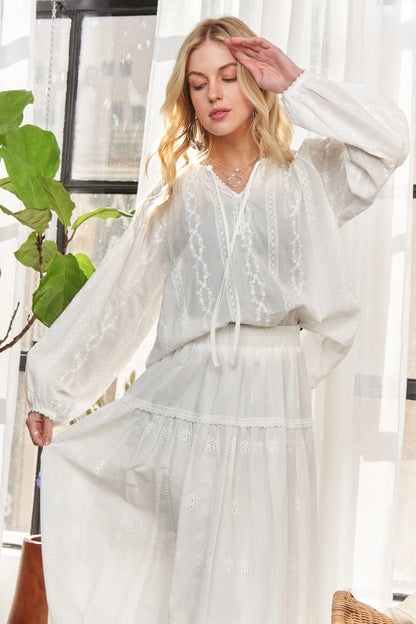 White ADORA cotton peasant top with a relaxed fit and gathered neckline, featuring long sleeves and lightweight fabric.